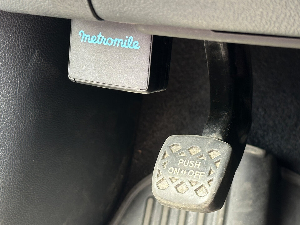Metromile OBD-II tracking device obstructing the parking brake in a Prius.jpg